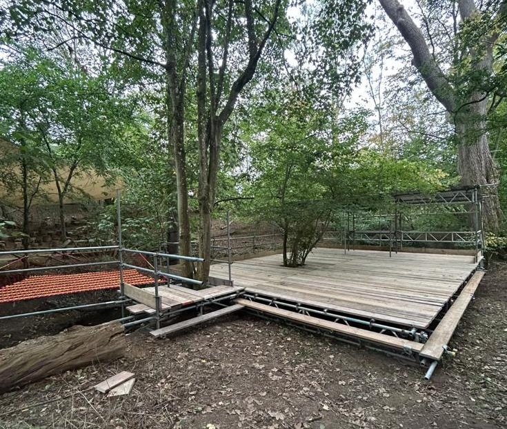 Completed festival scaffold stage with rear temporary roof structure and side access at Ridge Farm, Dorking