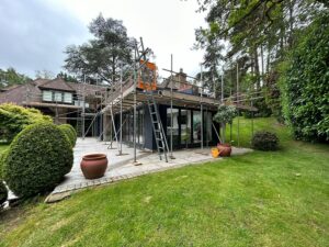 Single lift scaffold around a flat roof extension with ladder access at a house on St George's Hill, Weybridge
